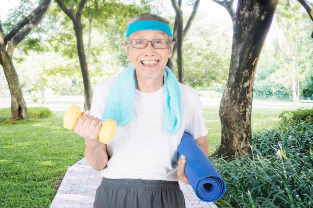 Photo un vieil homme avec une barre dans le parc.