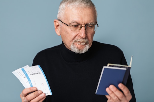 Vieil homme avec des billets d'avion et portrait de passeport