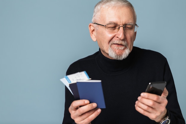 Vieil homme avec des billets d'avion et portrait de passeport