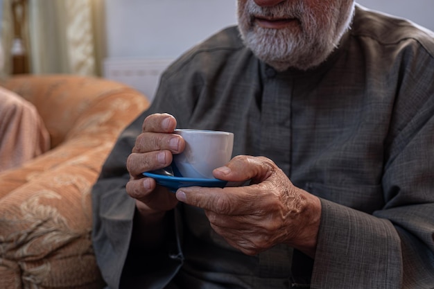 Vieil homme buvant du café avec le sourire sur son visage