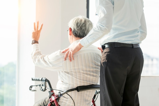 Vieil homme sur une chaise roulante et médecin à l&#39;hôpital Santé et concept médical pour comercial