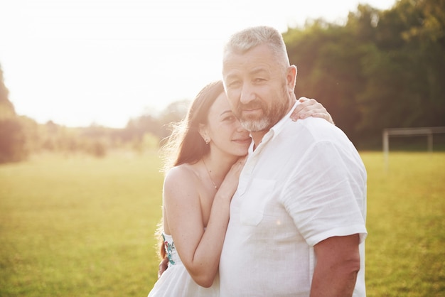 Un vieil homme a étreint sa fille adulte à l'extérieur