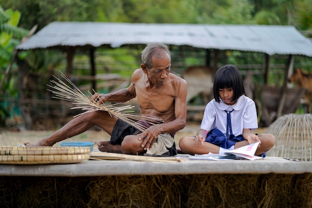 Vieil homme avec la fille étudiante et le métier de bambou