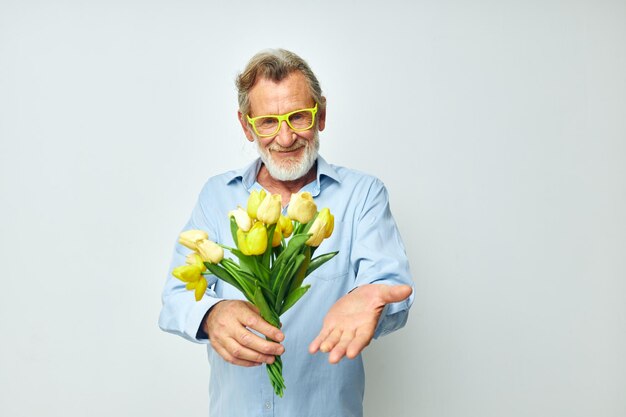 Vieil homme jaune bouquet de fleurs posant fond isolé