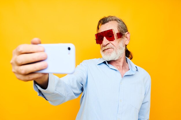 Vieil homme mode lunettes rouges téléphone selfie technologie