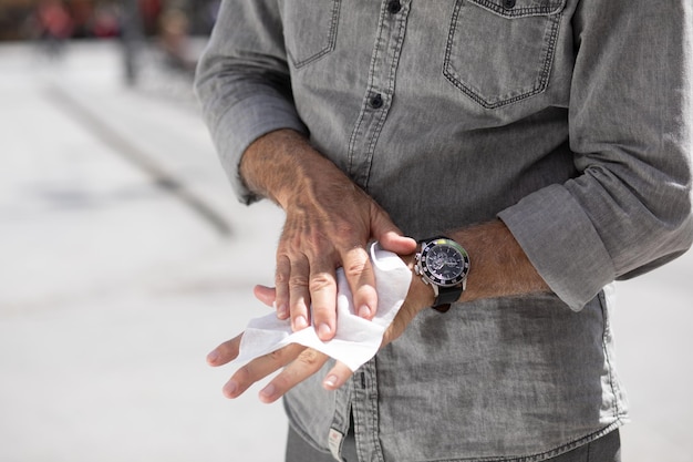 Photo un vieil homme se lave les mains avec des mouchoirs blancs.