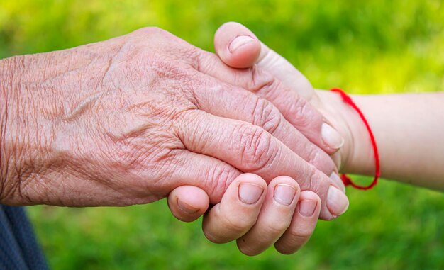 Vieil homme tenant les mains de l'enfant personnes de mise au point sélective