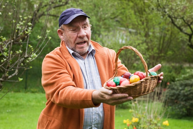 Vieil homme tenant un panier d'oeufs de Pâques