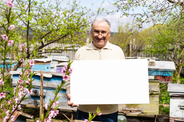 un vieil homme tenant une toile vierge.