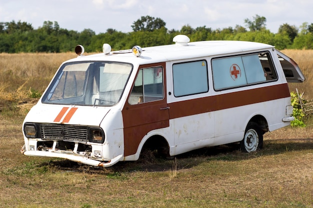 Vieille ambulance rouillée debout dans un champ