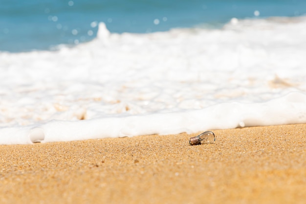 Une vieille ampoule repose sur la plage de sable