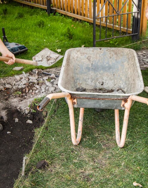 Une vieille brouette rouillée vide pour l'enlèvement du sol lors de la construction d'un nouveau jardin