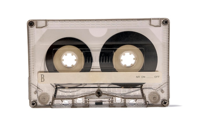 Une vieille cassette audio transparente pour un magnétophone isolé sur fond blanc