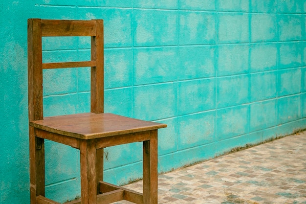 Vieille chaise en bois sur fond de mur bleu