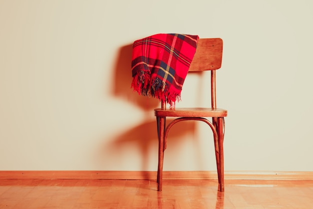 Photo vieille chaise avec couverture négligemment abandonnée dessus