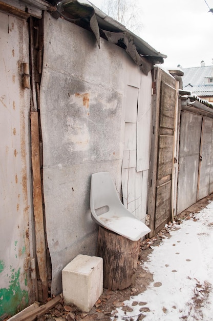 Une vieille chaise en plastique faite maison à côté des garages