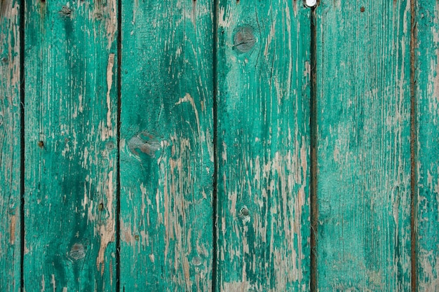 vieille clôture en bois peinte avec de la peinture verte fissurée du temps