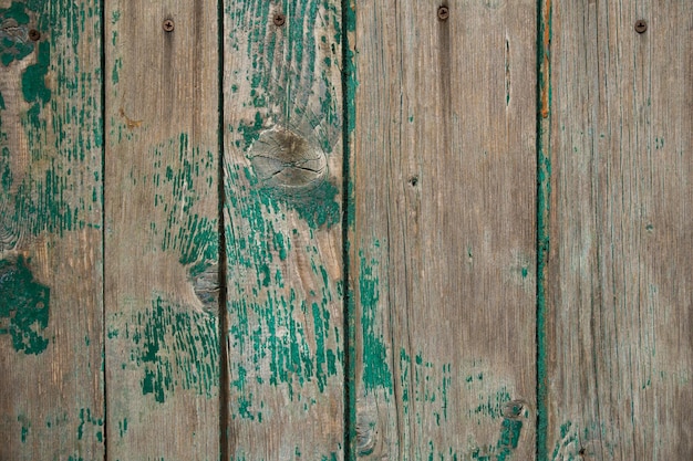 vieille clôture en bois peinte avec de la peinture verte fissurée du temps