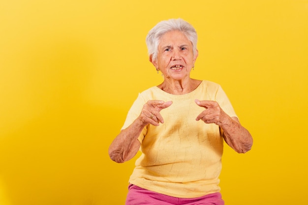 Vieille dame pointant vers l'index de la caméra en vous choisissant