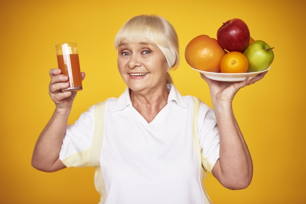 Vieille dame sportive au jus de fruits et d&#39;oranges fraîches