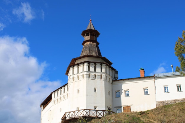 Une vieille église blanche se tenant sur une falaise contre un ciel bleu