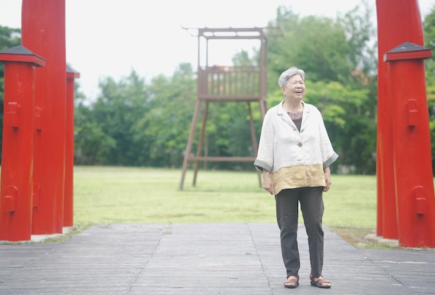 Photo vieille femme aînée âgée se reposant marchant dans le jardin