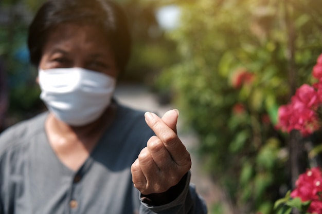 Vieille femme asiatique portant un masque en tissu blanc pour prévenir le virus Covid-19 ou Corona