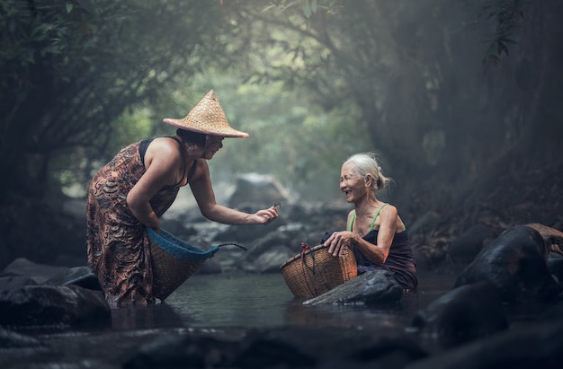 Vieille femme asiatique travaillant dans un ruisseau