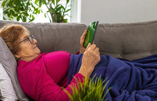 La vieille femme clique sur la tablette Mise au point sélective