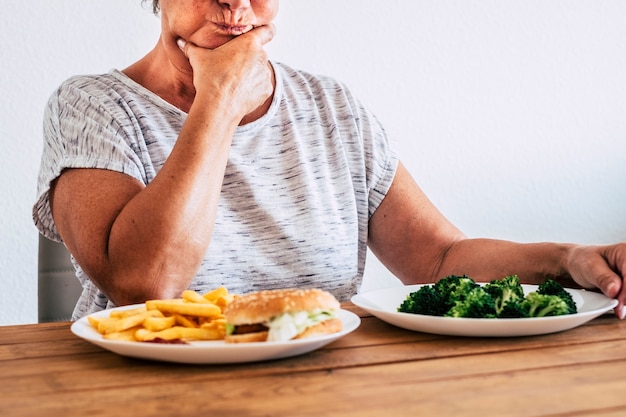 Une Vieille Femme Dégoûtée Regardant Et Mangeant Des Aliments Sains à La Maison Suivant Un Régime