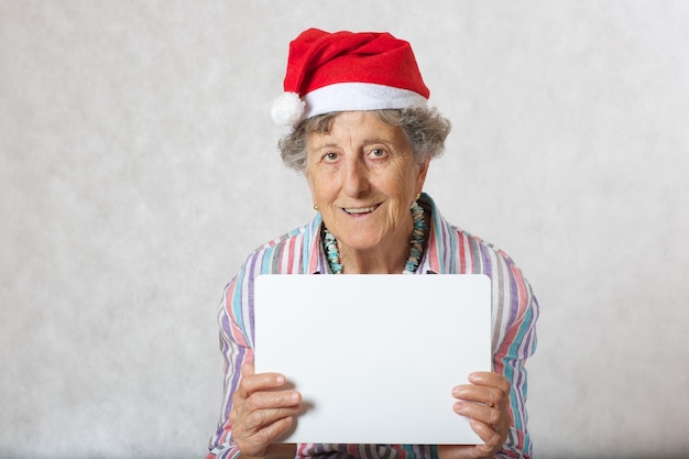 Vieille femme entre 70 et 80 ans dans le chapeau d'un père noël