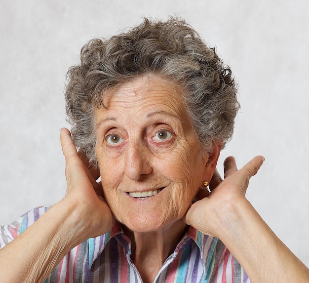 Vieille femme entre 70 et 80 ans montre qu'elle prend soin de ses cheveux