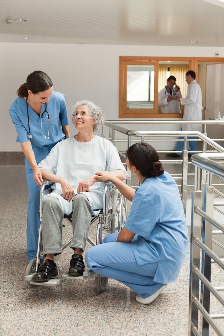 Photo vieille femme en fauteuil roulant parle avec des infirmières