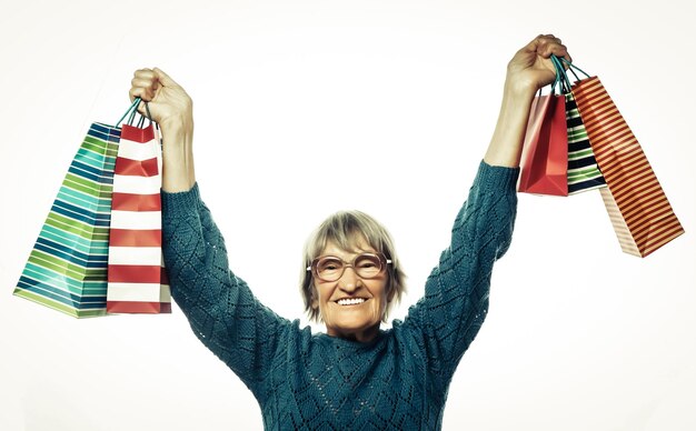 Photo une vieille femme heureuse avec des sacs à courses.