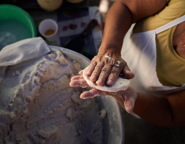 Photo une vieille femme méconnaissable prépare des tortillas de maïs à la main sur une grille dans sa modeste cuisine de rue.