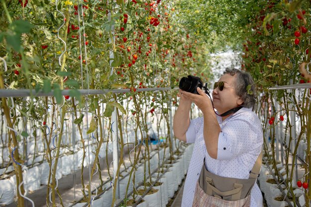 Vieille femme prenant une photo dans le jardinage. Prolonger la retraite active d&#39;une femme pour qu&#39;elle fasse des activités