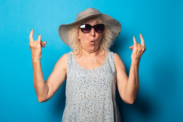 Vieille femme en robe et chapeau avec des lunettes de soleil