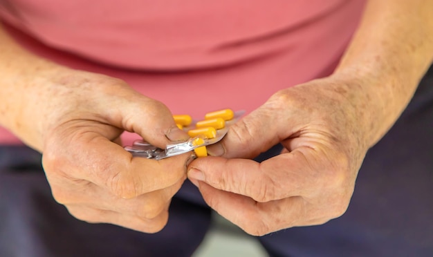 Une vieille femme tient des pilules dans ses mains Selective focus People