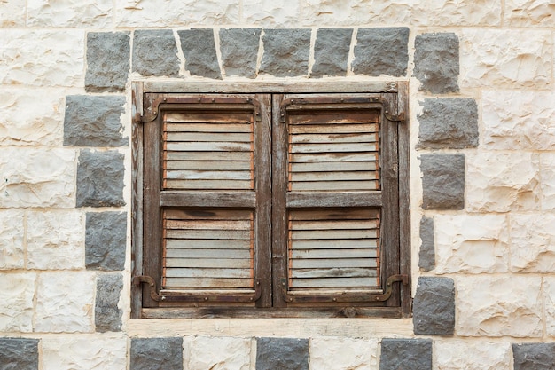 Vieille fenêtre en bois sur un mur de pierre
