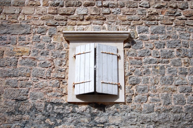 Vieille fenêtre en bois avec volets blancs d'une maison méditerranéenne, fond vintage