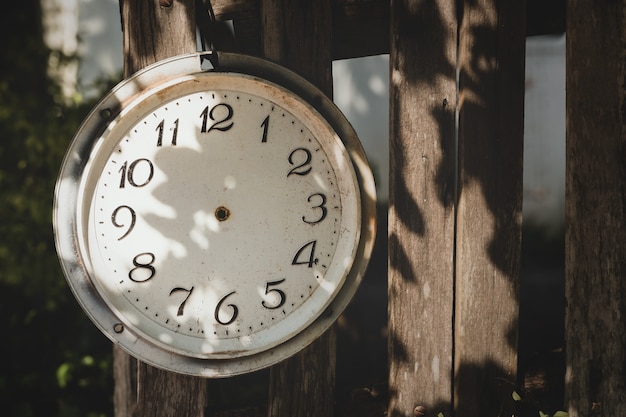 Vieille horloge vintage cassée sans flèches dans un jardin abandonné