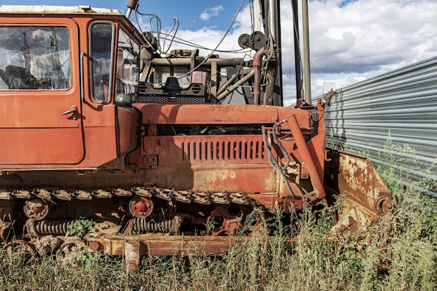 Une vieille machine bulldozer avec un godet lourd. Moissonneuse de terrassement avec chenilles sur un chantier de construction. Fermer. Machinerie lourde de construction.