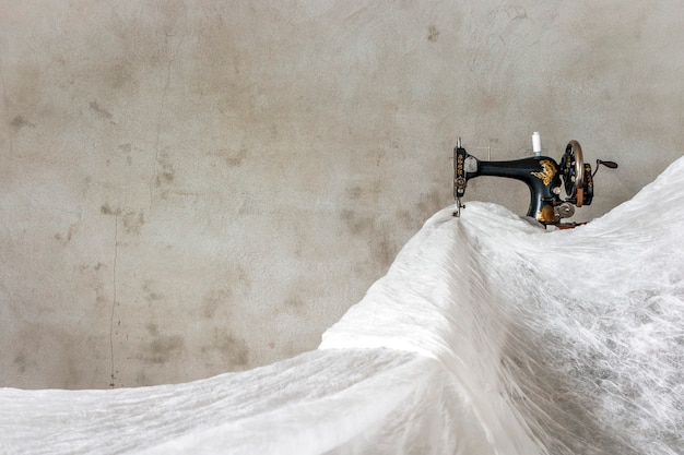 Photo la vieille machine à coudre et beaucoup de tissu blanc