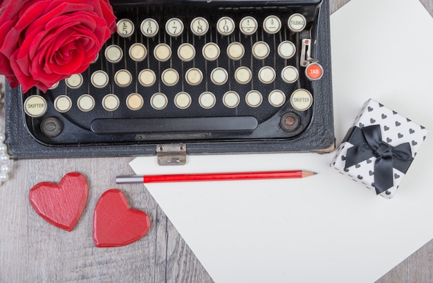 Vieille machine à écrire avec une rose rouge