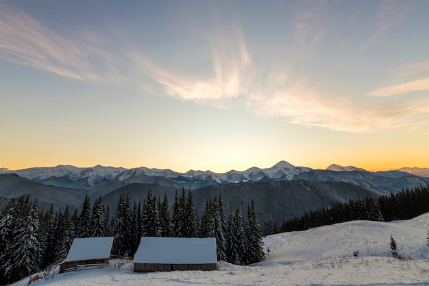 Vieille maison en bois dans la neige profonde sur la vallée de montagne