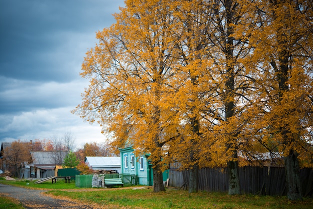 Vieille maison en bois dans le village, arbres, paysage de campagne en automne