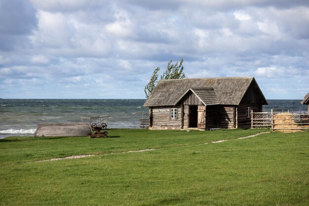 Une vieille maison en bois sur le rivage et un bateau de pêche renversé à côté