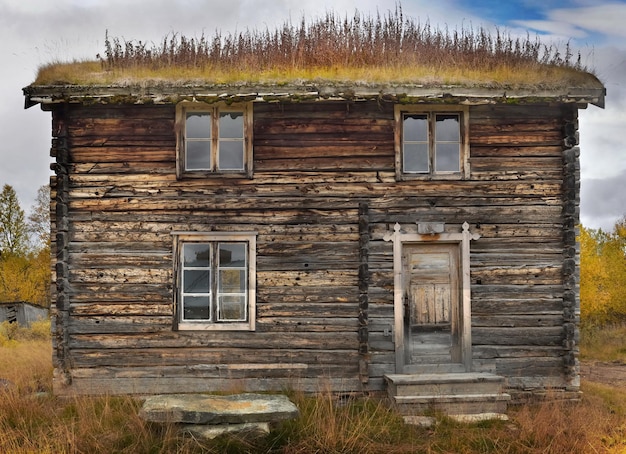 Vieille maison en bois traditionnelle en Norvège avec de l'herbe sur le toit