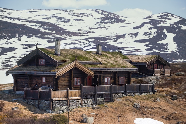 Vieille maison en bois traditionnelle norvégienne à Tyin et montagnes en arrière-plan, norvégien
