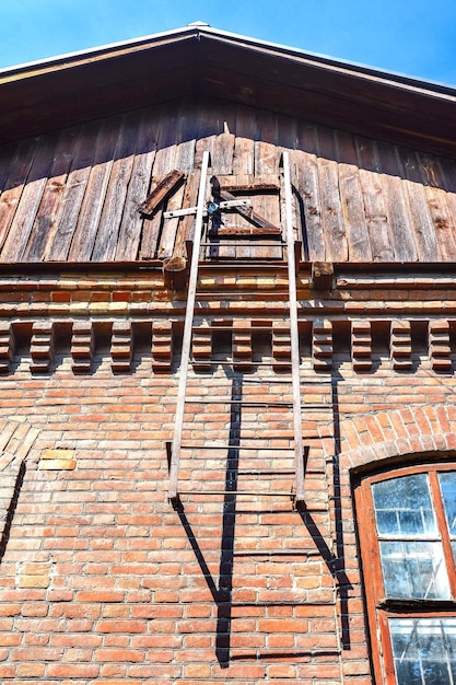 Une vieille maison en brique avec un toit en bois et un grenier